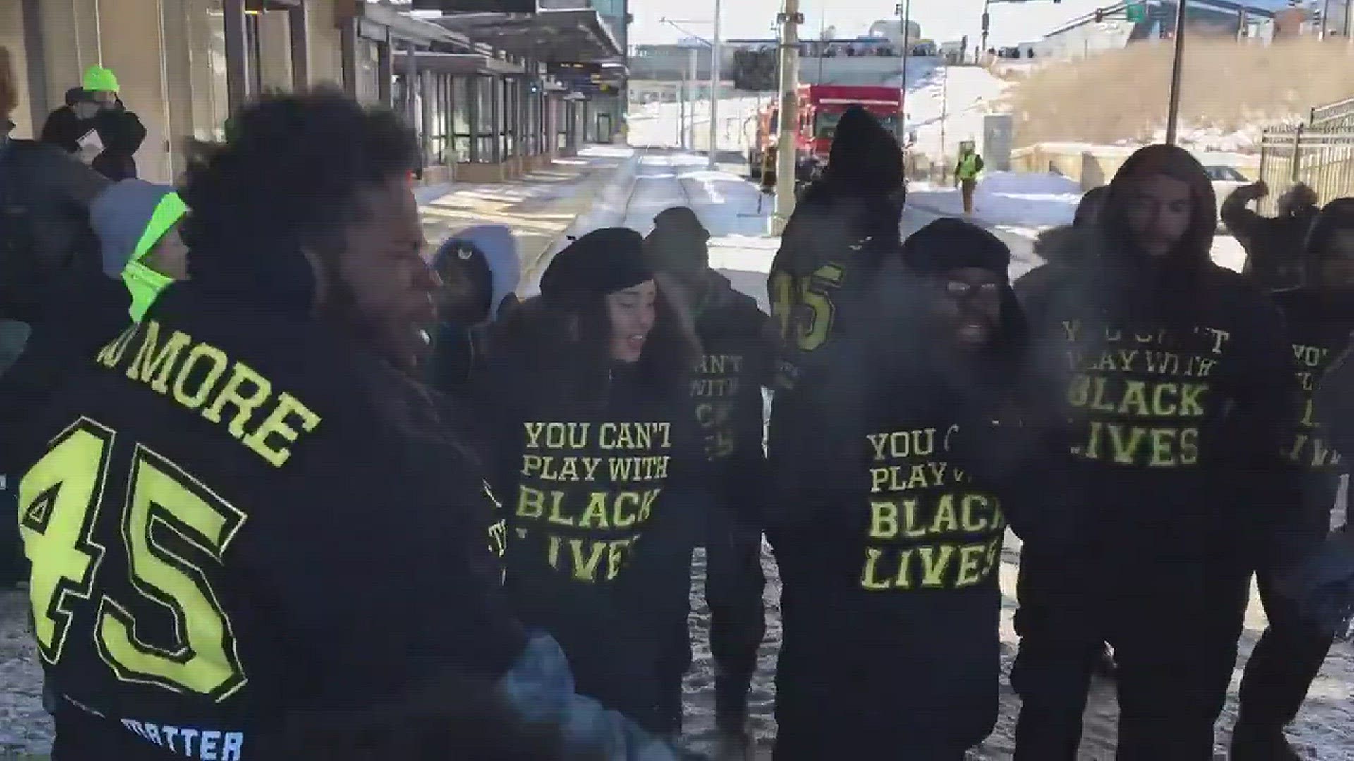 A small group of protesters are blocking east and westbound light rail trains on the Green Line at the West Bank Station near the Super Bowl.