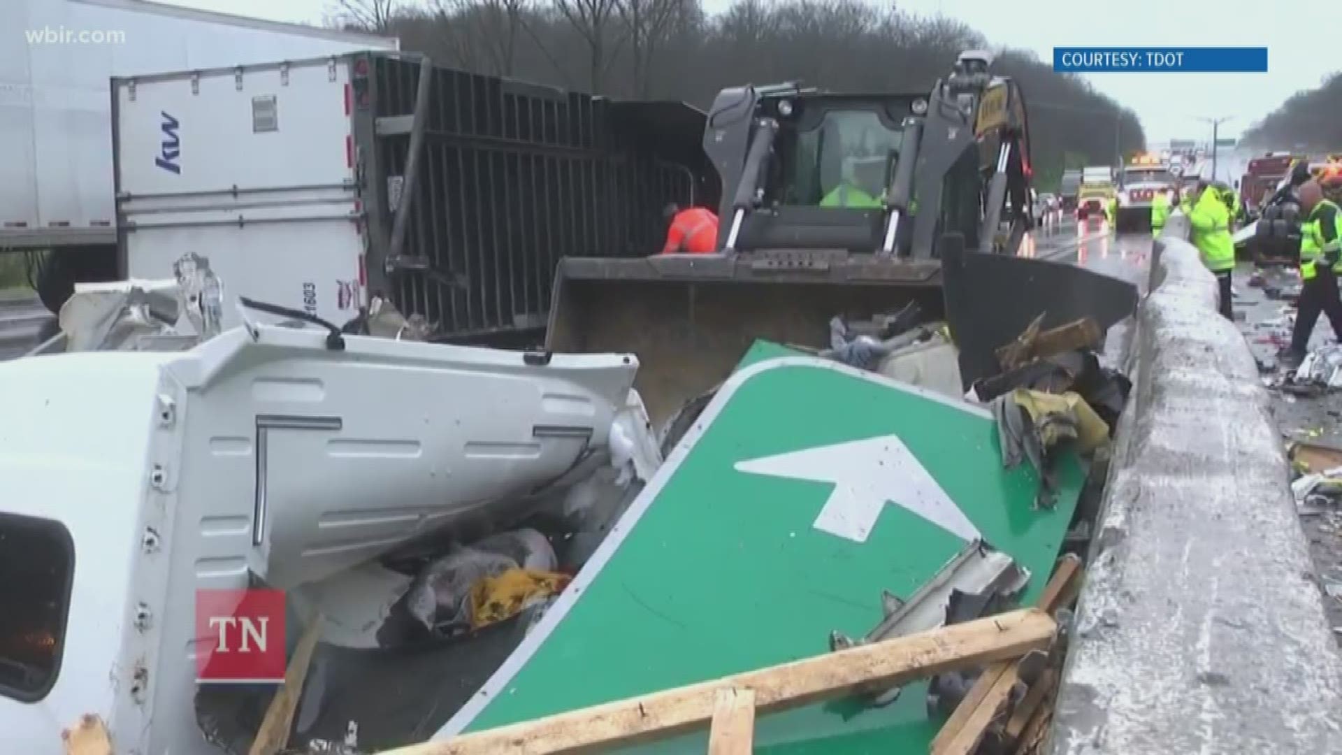 Police say that tractor-trailer lost control, hit the median and flipped. It also hit the overhanging interstate sign and knocked it down onto another vehicle.