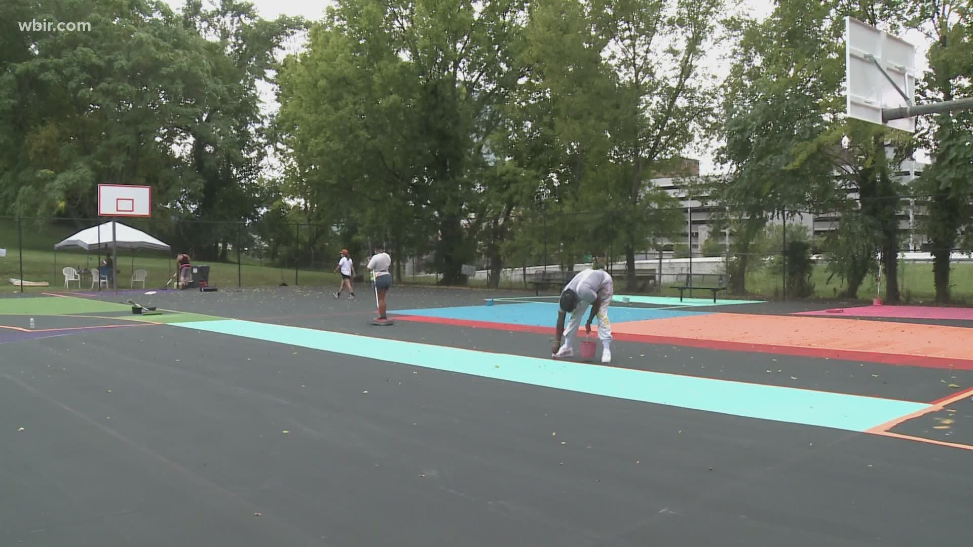 Volunteers from the community and local artists helped paint a colorful mural on the outdoor basketball courts at Cal Johnson Recreation Center.