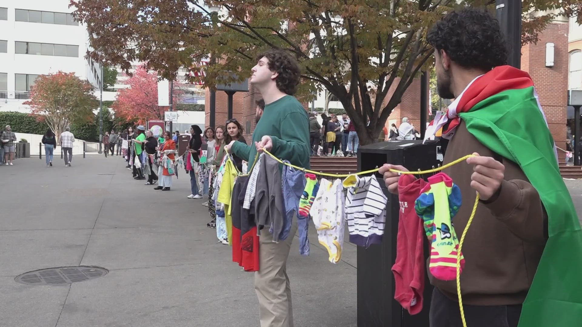 People hung children's clothing from a clothesline around Market Square, each piece of clothing meant to represent one of the over 4,000 children killed in Gaza.