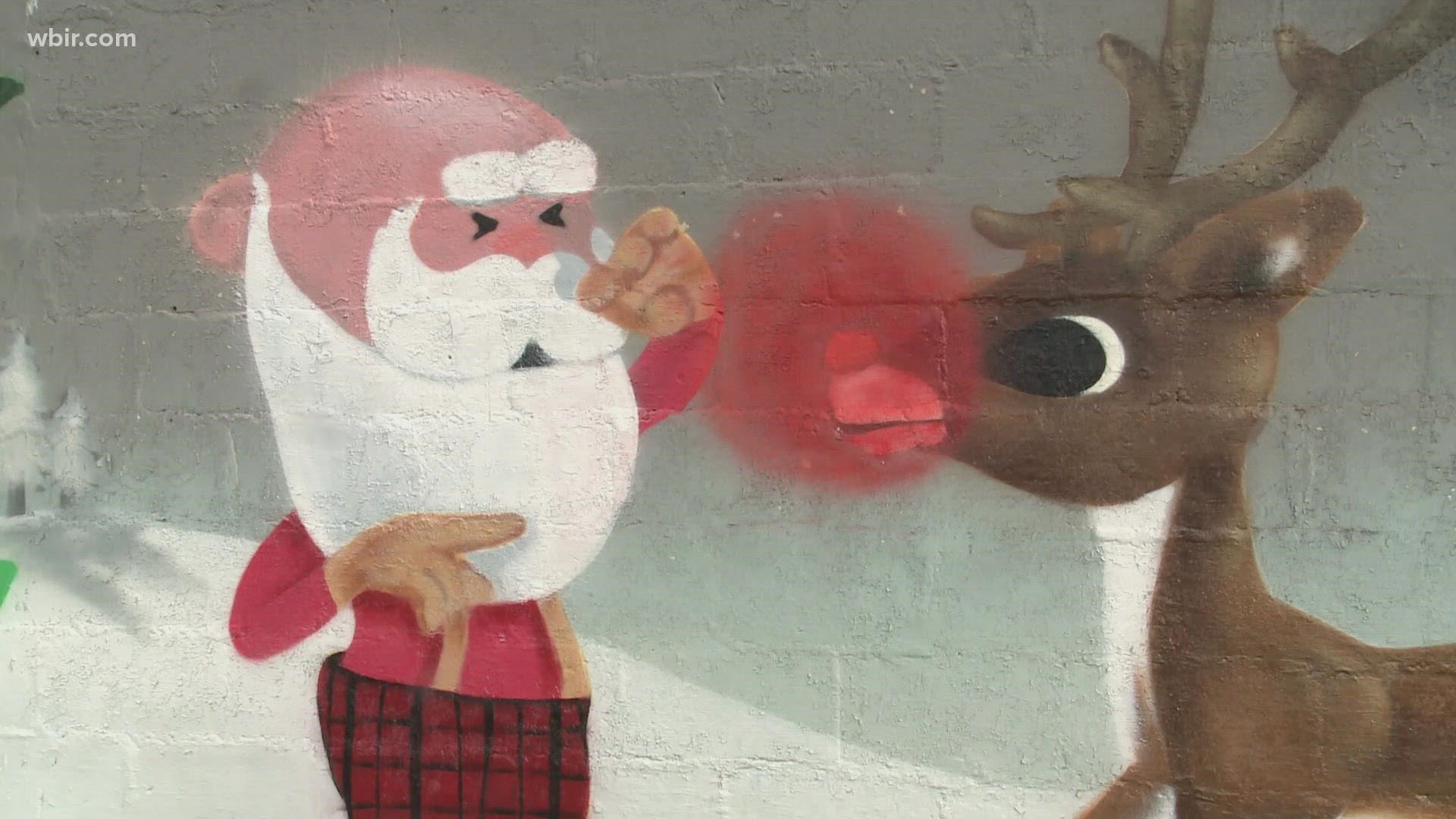 Instead of graffiti covering buildings on Atlantic Avenue, an artist is painting scenes from Rudolph the Red-Nosed Reindeer on them instead.