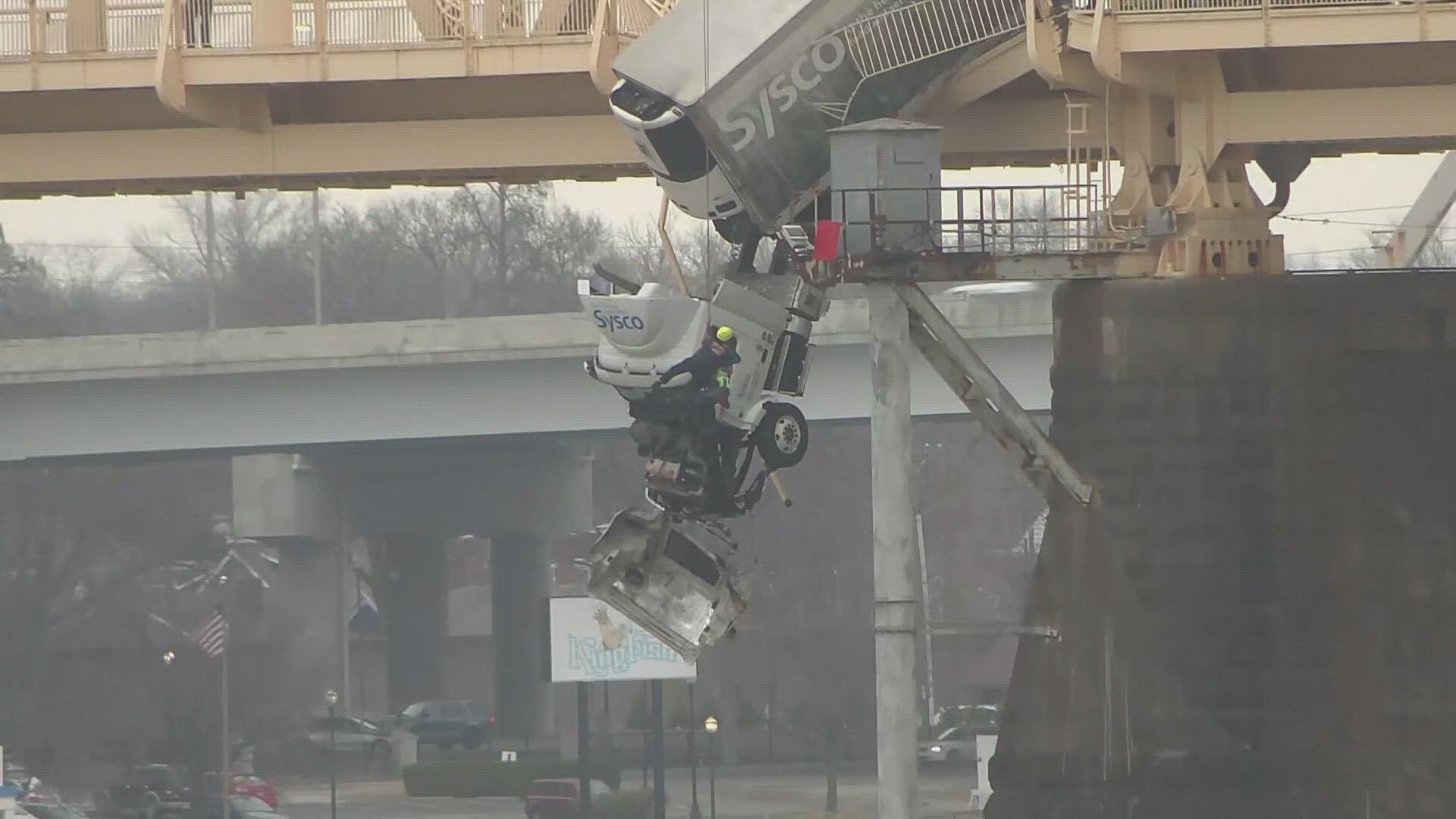 The woman's Sysco truck was involved in a three-vehicle crash Friday afternoon. She was in her cab for nearly an hour hanging over the edge.