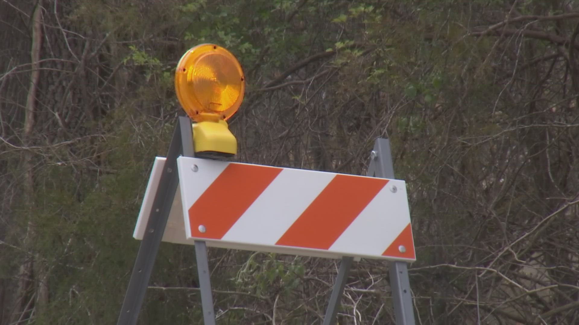 Temporary signage has been added with blinking lights to the dark country road ending with a ramp to the Tennessee River.