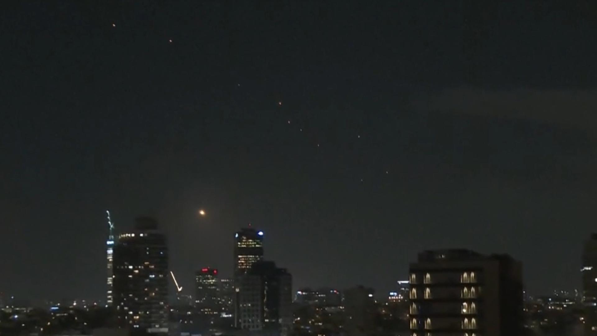 NBC crews captured video of orange fire lighting up the sky over Tel Aviv as booms were heard in the distance.