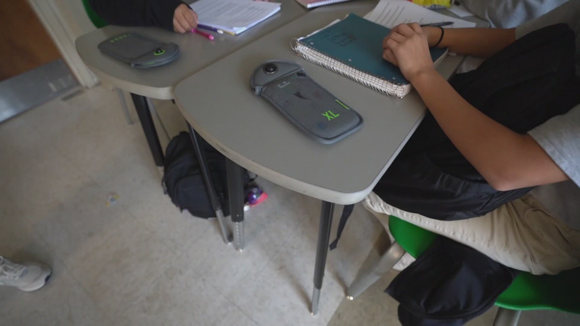 Students' phones and electronics are kept in special pouches throughout the school day.