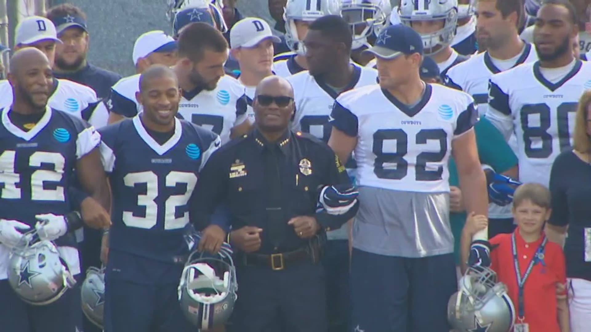 Dallas Police Chief David Brown walked onto the practice field in Oxnard Saturday, locking arms with Cowboys players.